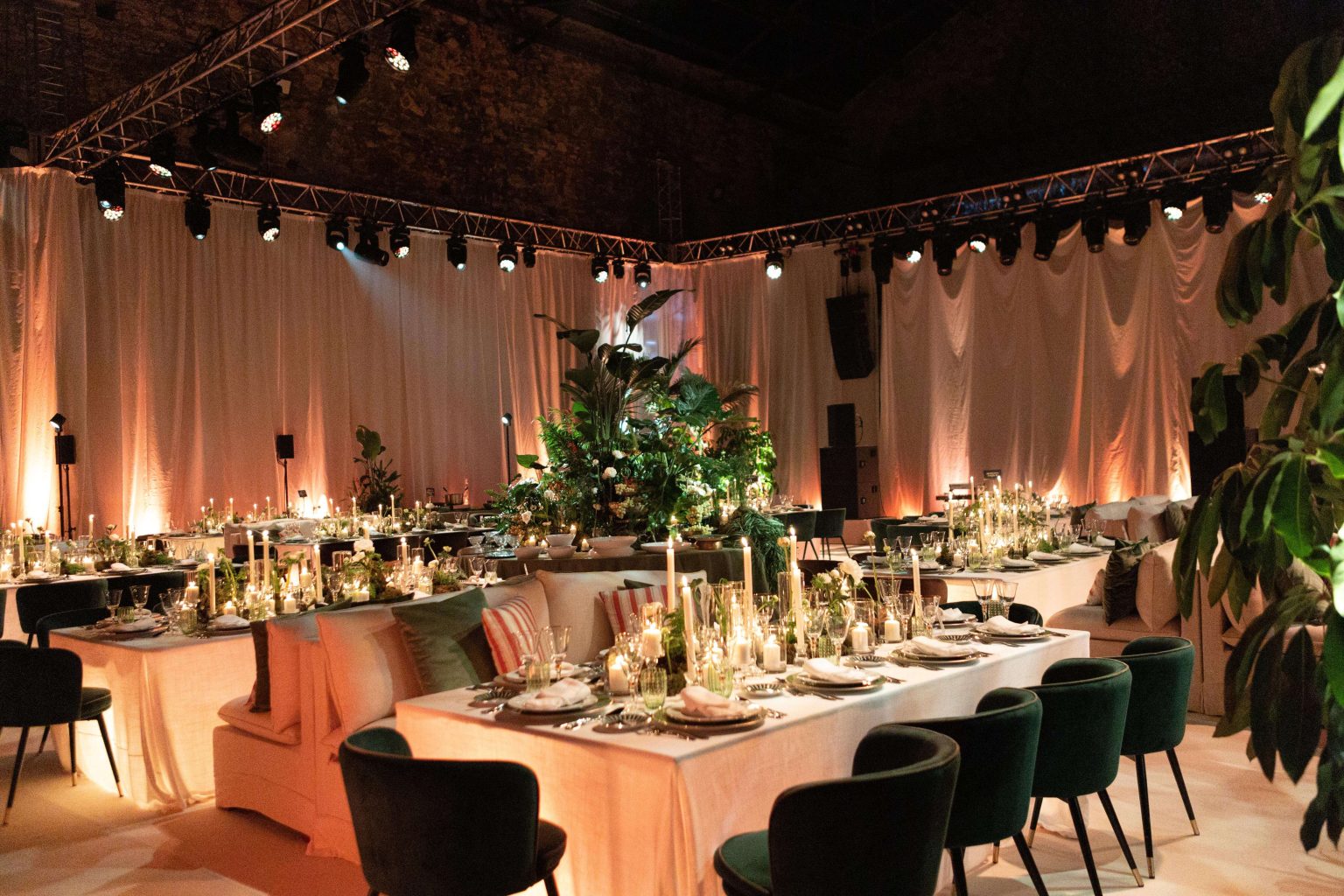 Espaço interior decorado para uma festa privada, com iluminação e arranjos florais